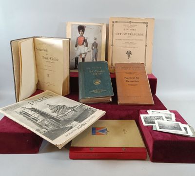 several old books are sitting on a red tablecloth on a white surface