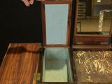 a person pointing at a small wooden table with a mirror on it