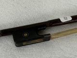 a violin bow and a bow rest on a white surface
