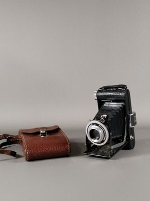 deux vieux appareils photo et un étui en cuir posés sur la table