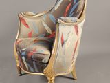 an upholstered chair with a colorful upholstered seat and gold legs