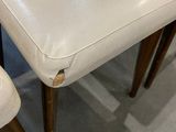 two white chairs sitting next to each other in a room
