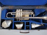 a silver trumpet in a blue case on a table