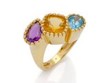 gros plan d'une bague en or avec trois pierres de couleurs différentes