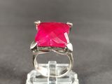 pink stone ring on a clear acrylic stand on a table