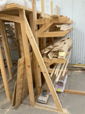 plusieurs pièces de bois sont empilées dans un entrepôt