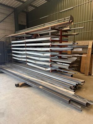 a large pile of steel beams in a warehouse