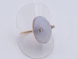 a close up of a ring on a clear surface with a diamond