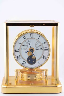 a gold clock with a blue moon in the center