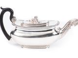 silver plated teapot with black handle on white background