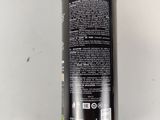 a close up of a bottle of black liquid on a white surface
