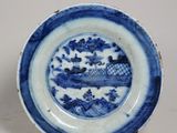 une assiette bleue et blanche sur laquelle est représenté un bateau