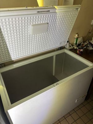 a white chest freezer sitting on a tiled floor
