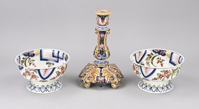 two vases and a candle holder are sitting next to each other