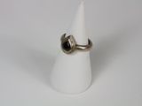 silver ring with a black stone in the middle on a white cone