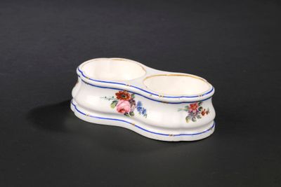 un petit bol blanc orné d'une bordure bleue et de fleurs