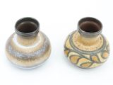 two small vases sitting side by side on a white surface
