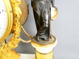 a statue of a woman holding a clock next to a clock