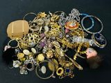 a pile of assorted jewelry on a black surface