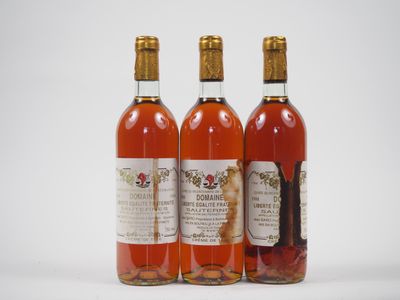 trois bouteilles de vin posées les unes à côté des autres sur une surface blanche