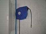 a blue hose attached to a wall in a bathroom
