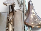 many pieces of luggage and a bicycle hanging on a wall