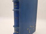 un livre bleu orné d'étoiles dorées et d'un croissant