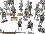 silver figurines of soldiers with weapons and a flag on a white background
