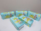 four packs of baby diapers sitting on top of a table