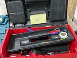 une boîte à outils rouge avec des outils sur une table