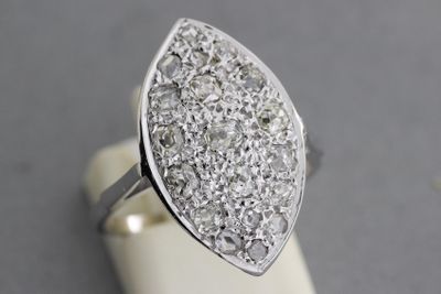 un gros plan d'une bague en diamant posée sur un présentoir, sur une table
