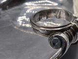 a silver ring sitting on top of a silver tray