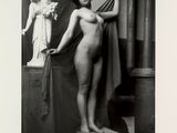 photographie en noir et blanc d'une femme nue debout sur un piédestal