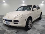 une photo d'une Porsche Cayenne blanche garée dans un garage