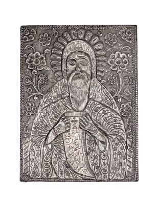 une plaque métallique argentée sur laquelle figure l'image d'un homme barbu