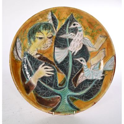 une assiette sur laquelle est représenté un homme et des oiseaux