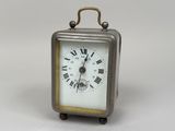 une petite horloge en argent ornée de chiffres romains
