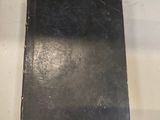 an old book sitting on top of a white table