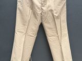 une photo d'un pantalon beige suspendu à une corde à linge