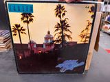 someone is holding a picture of a building with palm trees in the background