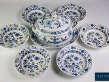 plusieurs assiettes et bols bleus et blancs posés sur une surface blanche