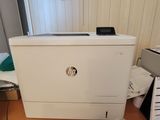 une imprimante blanche posée sur un bureau, à côté d'un ordinateur portable