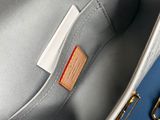 a close up of the inside of a grey bag with a gold handle