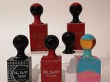 trois petits flacons de parfum posés l'un à côté de l'autre sur une table