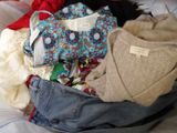 a pile of clothes sitting on top of a bed
