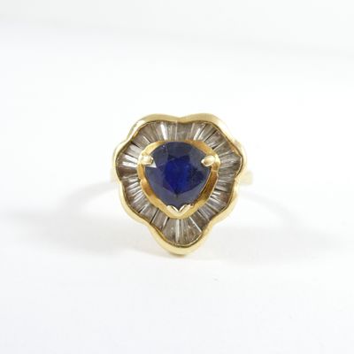 a close up of a gold ring with a blue stone in the center
