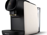 a close up of a coffee maker with a glass of water