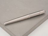 a silver pen sitting on top of a piece of paper