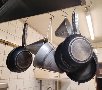 des casseroles et des poêles suspendues au plafond dans une cuisine