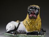 une sculpture en céramique représentant un lion couché par terre
